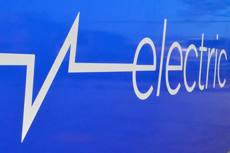Close-up of white "electric bus" logo on side of blue Chicago public transit bus